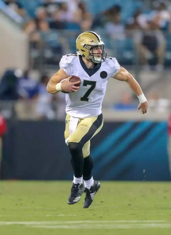pro football quarterback Taysom Hill running with a football