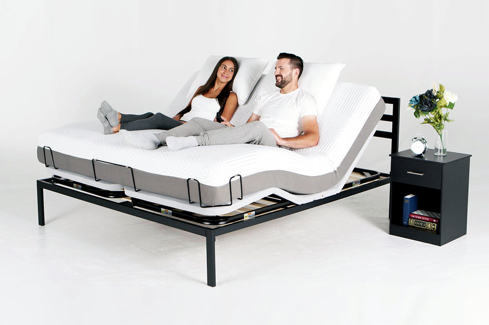 a couple sitting on a bed with a PowerLayer and the head/foot sides raised